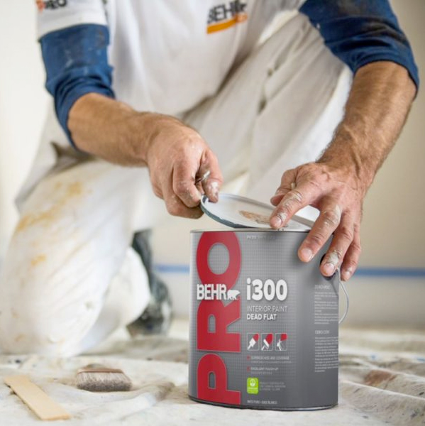 Painter opening a can of Behr paint