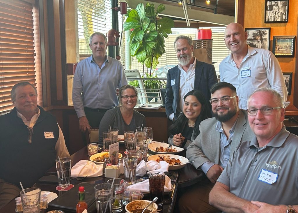 Group of people gathered at a table for a partner networking event in Texas.