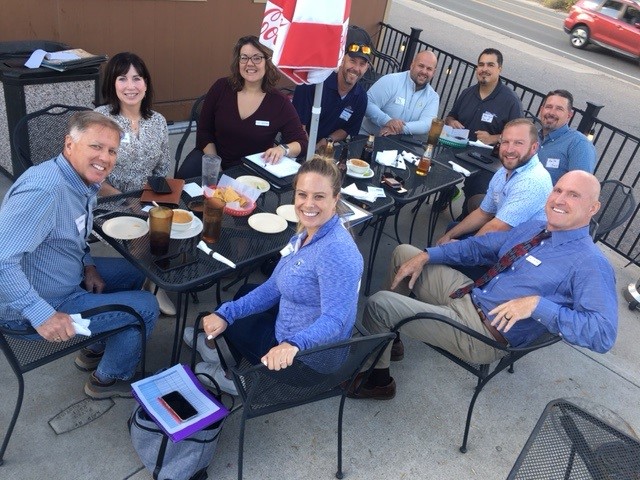 A group of people gathered together at a table for a partner networking event in Denver.